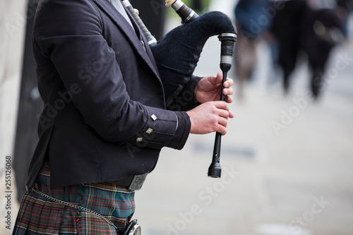 Photographie Scottish bagpiper dressed in traditional dress performing on the street