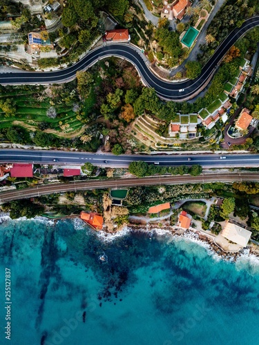 Aerial view of road, highway and railway going along ocean or sea. Drone photography in rural Italy