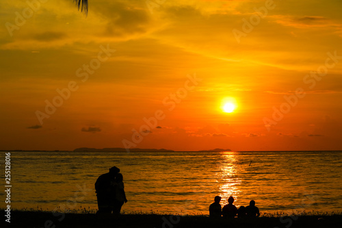 silhouette of lover standing and family sitting look at sunset