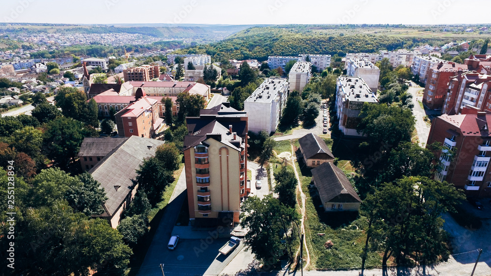 Aerial view of a small city with new large modern comfortable houses with a brown tiled roof on a summer day. View from above