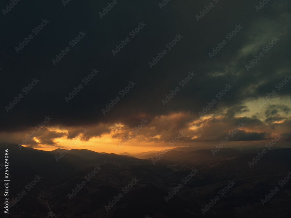 Epic wanderlust scene of a mountain glowing by sunlight at twilight dramatic sky