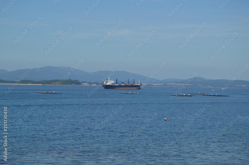 Tanker Ship Navigating The Estuary In Front Of The Horse Point Lighthouse On Arosa Island. Nature, Architecture, History, Travel. August 18, 2014. Isla De Arosa, Pontevedra, Galicia, Spain.