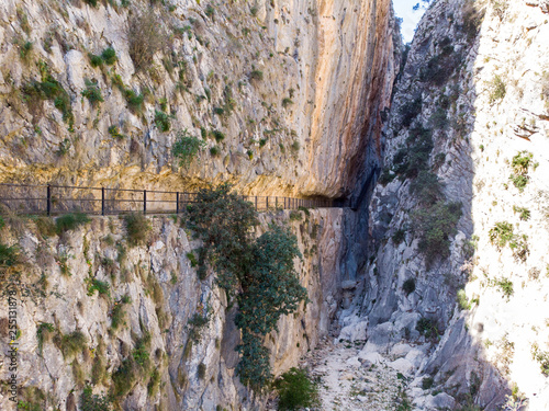 A path through the rocks at Reservoir of Isbert, an empty and dry lake, Barranc de l’Infern, The Hell’s Ravine, in Orba and Vall de Laguar, Alicante, Spain photo