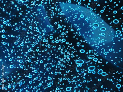 Close - up of air bubbles of different colors, in water isolated on dark background