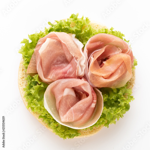 Sandwich with lettuce, salami on white background.