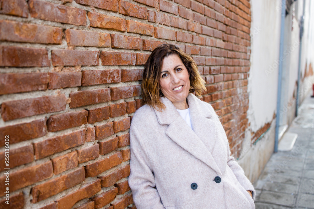 Portrait of a middle aged woman with a pink coat