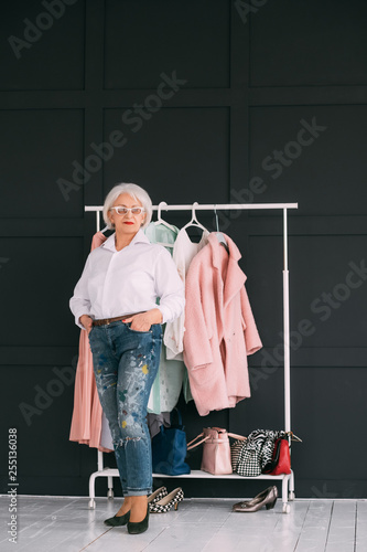 Senior fashion trends. Personal style. Confident elderly woman demonstrating wardrobe. Copy space. photo