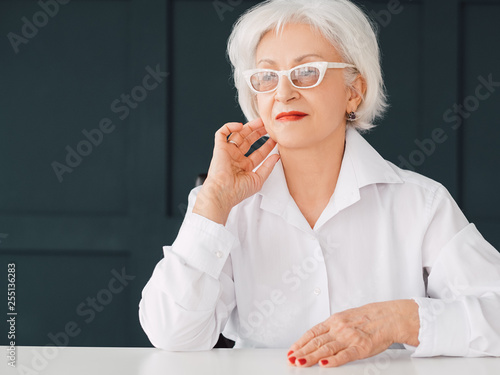 Thoughtful senior business lady portrait. Modern seniority independence. Copy space. photo