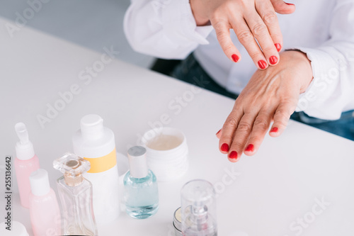 Senior woman hands care. Wrinkled skin beauty products. Aged lady applying care cosmetics.
