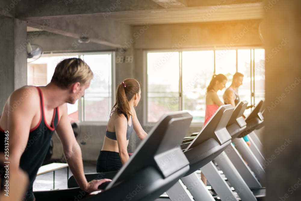Woman and man running on treadmills doing cardio training in a gym together,Healthy lifestyle concept Woman and man running on treadmills doing cardio training in a gym together,Healthy lifestyle concept