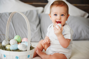Portrait of baby eating easter egg in bed