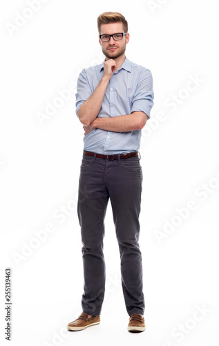 Full length portrait of young man standing on white background © pikselstock