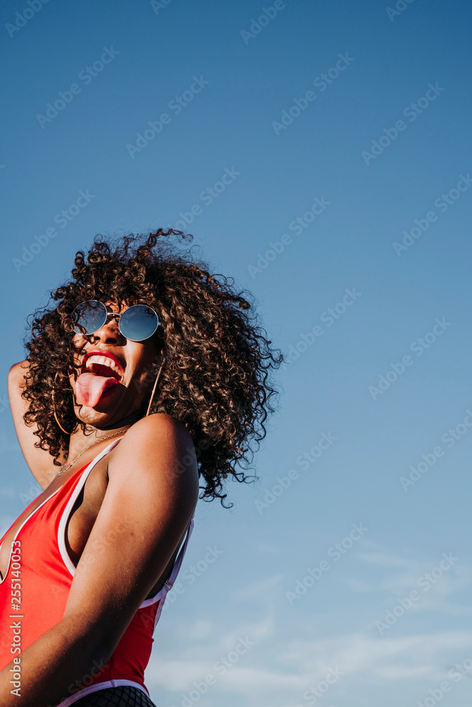 Beautiful afro american woman sticking out tongue in the street Beautiful afro american woman sticking out tongue in the street