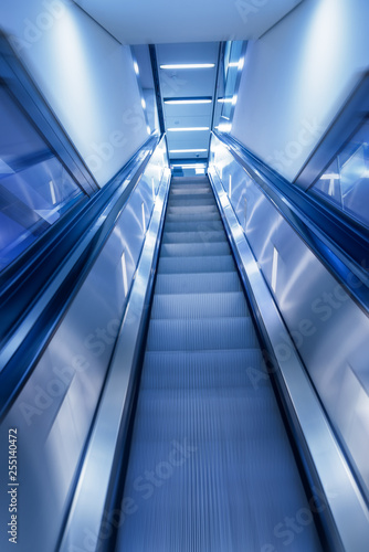 Business Concept shot motion blur of escalator leading up in modern building. perfect background for business related project