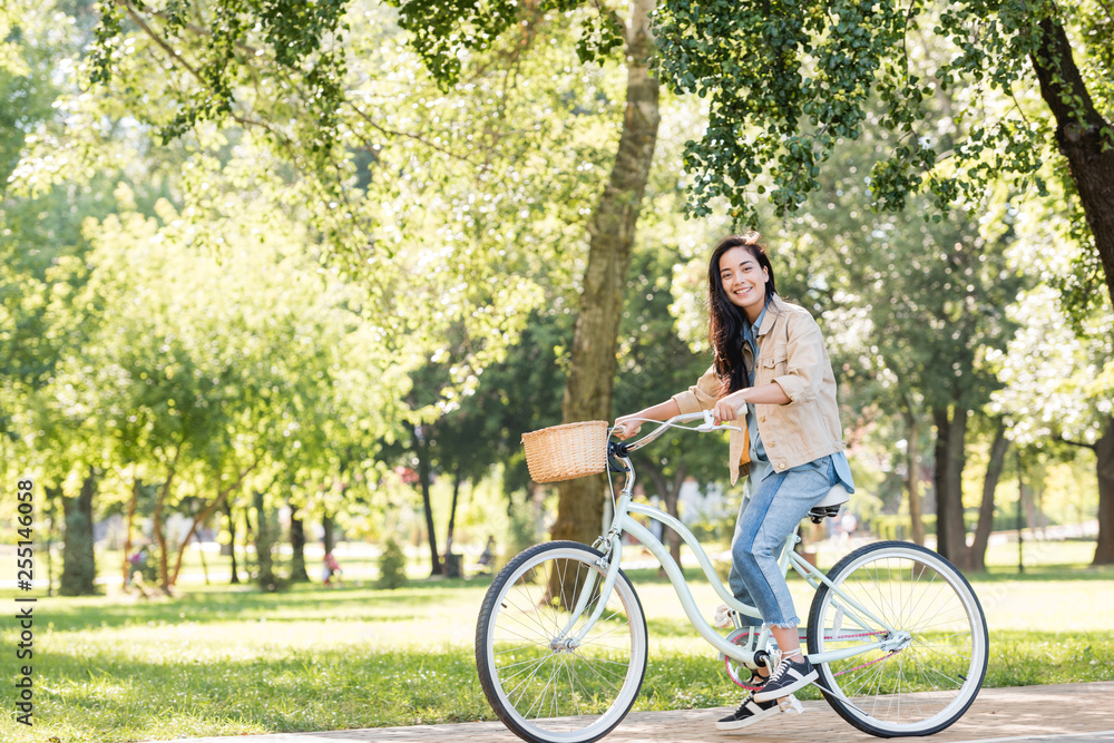 happy pretty girl smiling while riding bicycle in park happy pretty girl smiling while riding bicycle in park