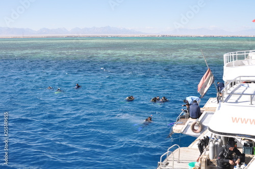 Hurghada, Egypt - January 1, 2018, several people swimming before the diving, stern of the boat