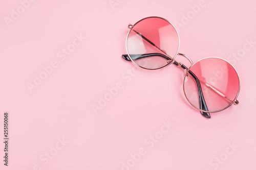 Round gradient sunglasses isolated on pink background.