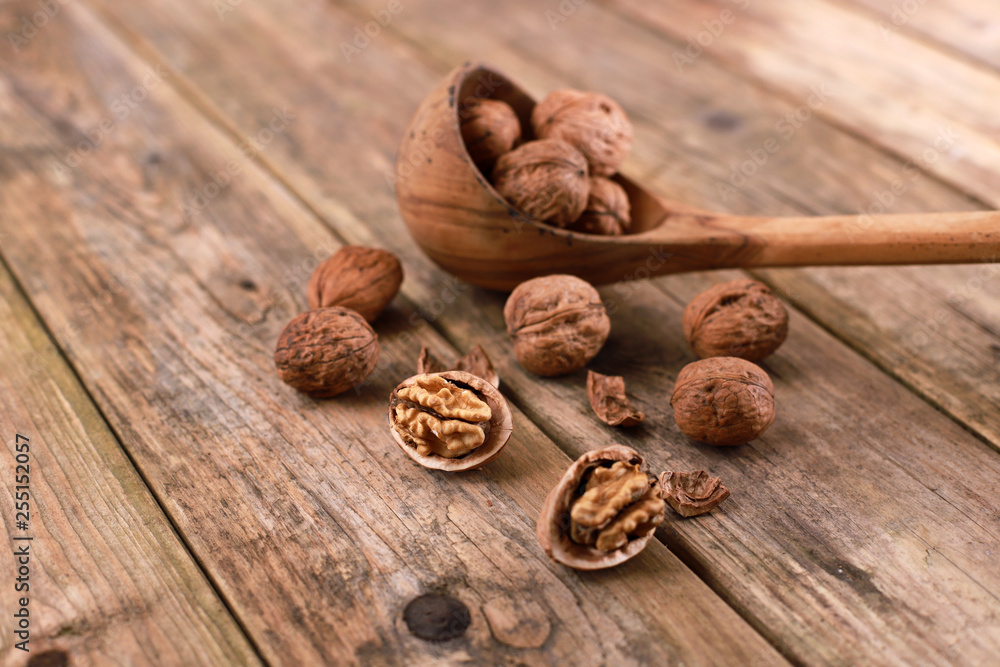 walnuts on a rustic wooden table - close up - walnuts broken up and closed walnuts on a rustic wooden table - close up - walnuts broken up and closed