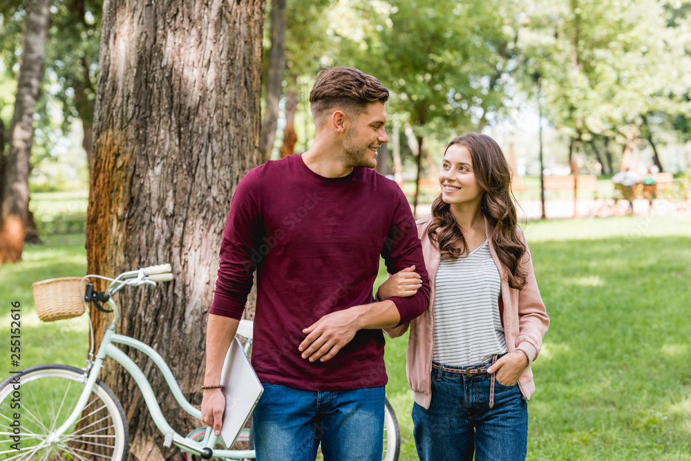 cheerful man looking at beautiful girl with hand in pocket cheerful man looking at beautiful girl with hand in pocket