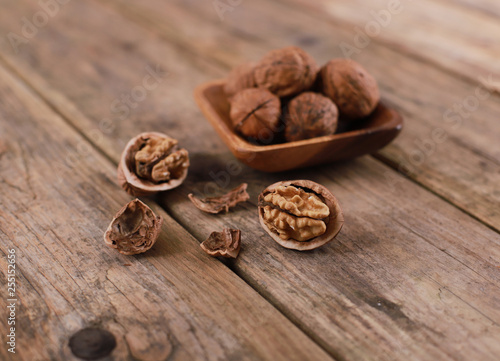 walnuts on a rustic wooden table - close up - walnuts broken up and closed
