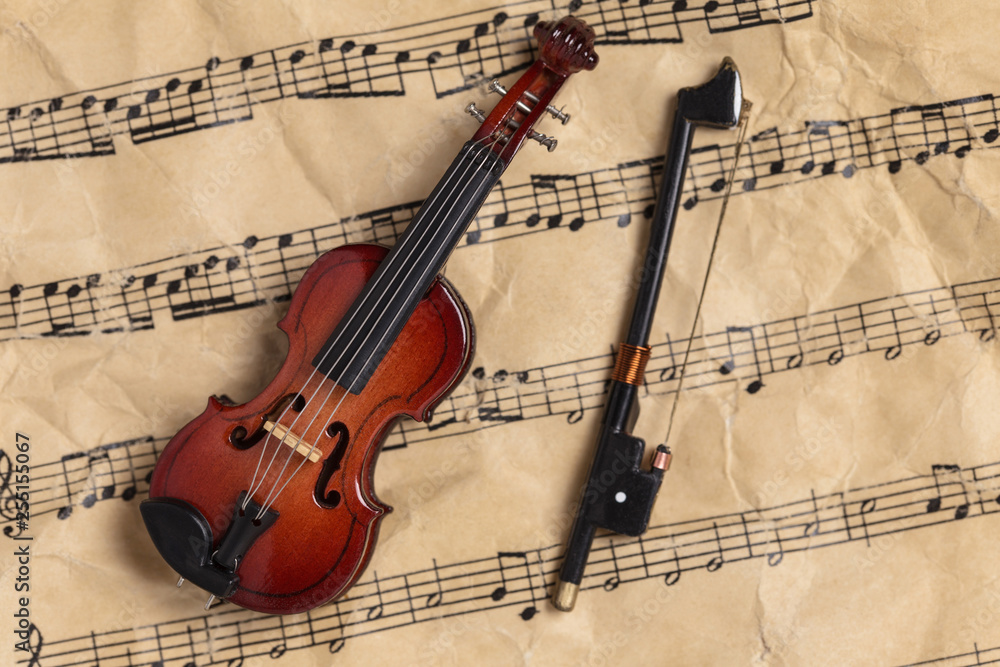 Fototapeta premium Violin on old paper music notes with copy space