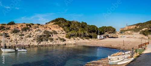The beach of Portinatx is located in the north of the island of Ibiza. A part of the beach also serves as a refuge for recreational and fishing boats. In the background we see the Moscarter lighthouse