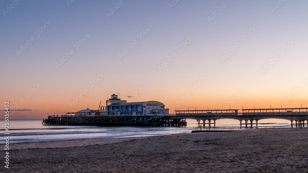 Glorious sunset over the beautiful pier and the sandy beach of Bournemouth, England