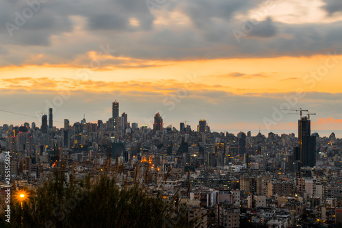 This is a capture of the sunset in Beirut capital of Lebanon with a warm orange color  and you can see Beirut downtown in the foreground with some beautiful cloud in the background