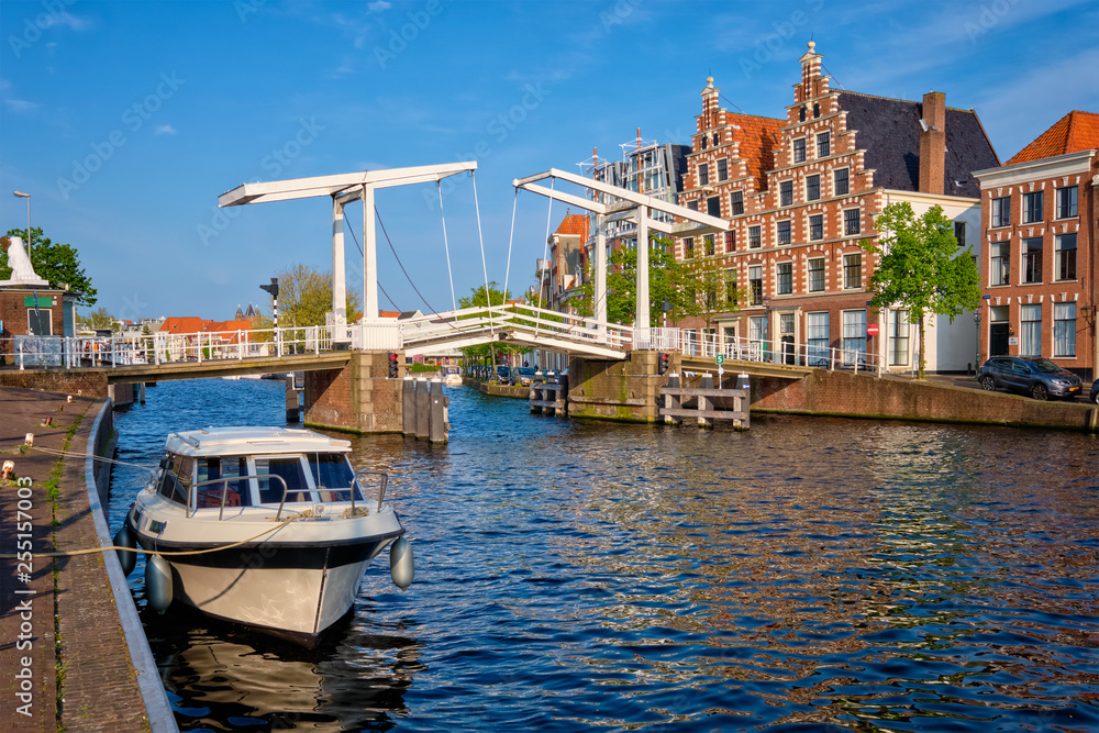 Spaarne river with boat and Gravestenenbrug bridge in Haarlem, Netherlands
