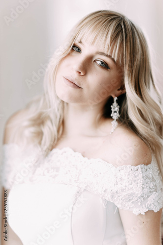 Portrait of a beautiful blonde bride in a lace wedding dress.