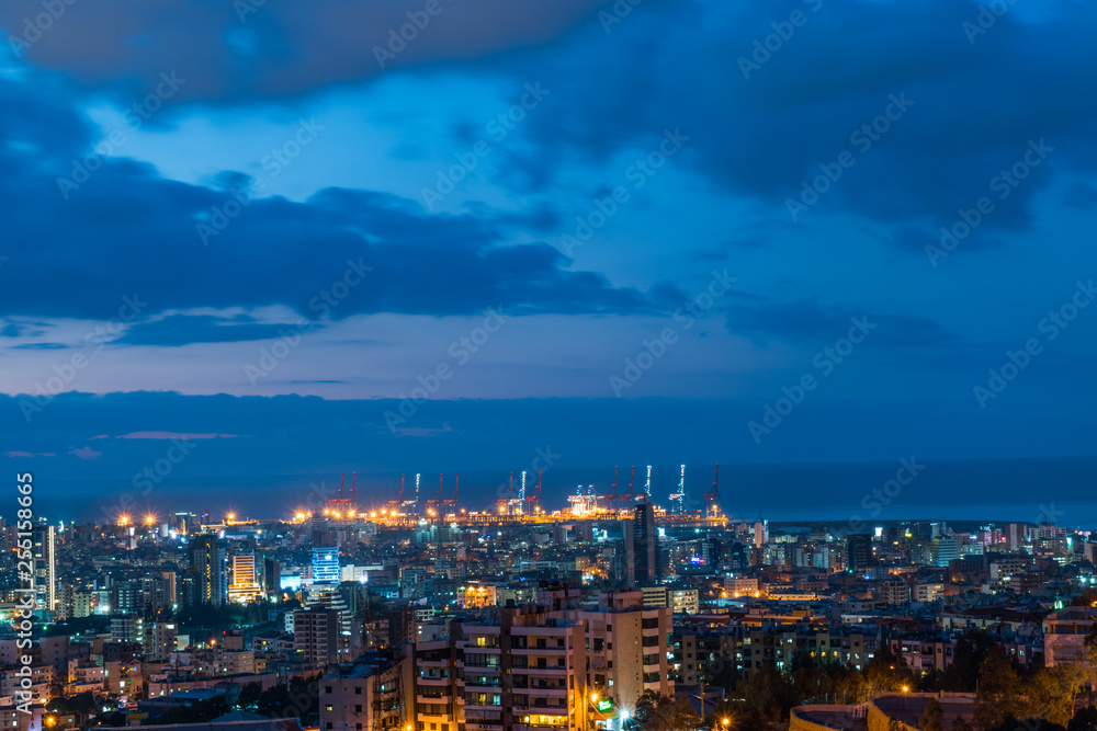 This is a capture of the sunset in Beirut capital of Lebanon with a warm orange color and cool tone cloud and you can see Beirut port in the picture.