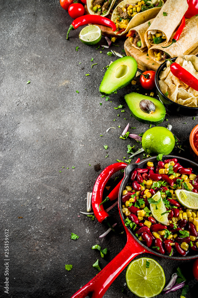 Cinco de Mayo food.Mexican food concept background with taco, quesadilla, burrito, chili, salsa sauce, hot pepper, lime. Black concrete background top view copy space