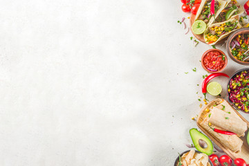 Cinco de Mayo food.Mexican food concept background with taco, quesadilla, burrito, chili, salsa sauce, hot pepper, lime. Black concrete background top view copy space