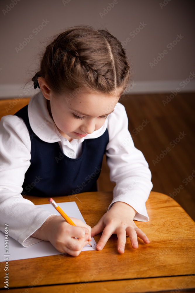 Little Girl Writing While Sitting in Old School Desk - Education Little Girl Writing While Sitting in Old School Desk - Education