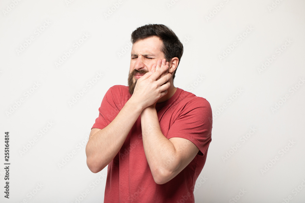 Young man suffering from toothache on grey background Young man suffering from toothache on grey background