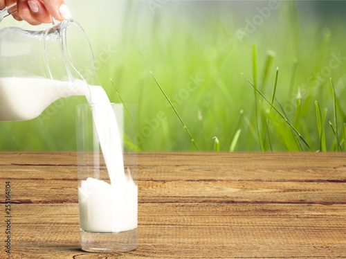 Glass jug of fresh milk  on background