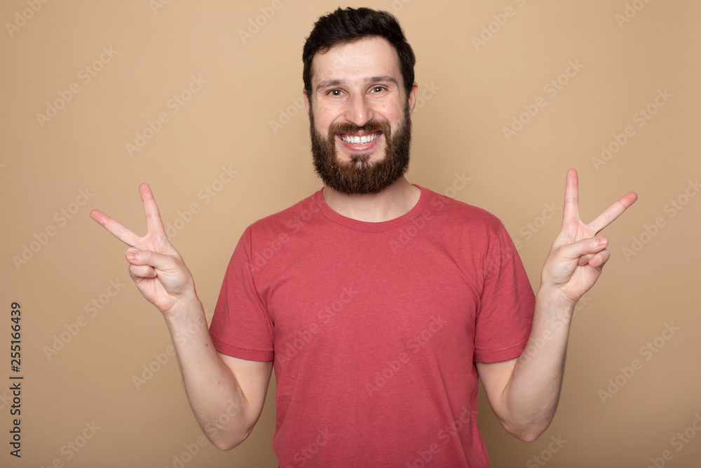 Young bearded man laughing, studio shot.