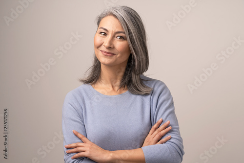 Smiling Asian senior woman with crossed arms photo