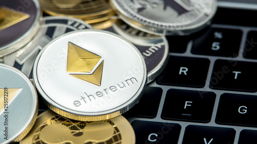 Physical metal silver Ethereum currency on notebook computer keyboard ETH photo