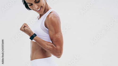 Fotografia Close up of a smiling fitness woman looking at her hand
