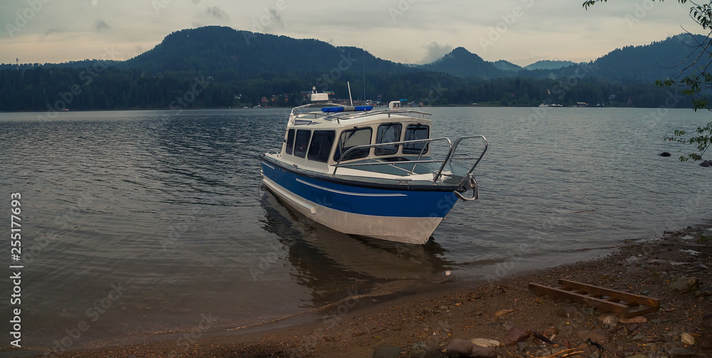 Fototapeta premium summer landscape on a mountain lake. fog over forest. ships and boats floating near the shore on the water