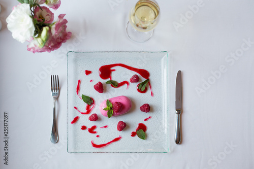 dessert with raspberries and white wine in a restaurant photo