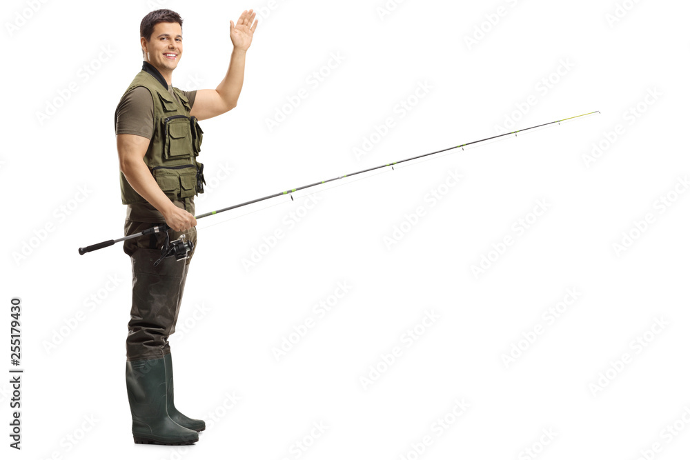 Young male fisherman holding a fishing rod and waving at the camera Young male fisherman holding a fishing rod and waving at the camera