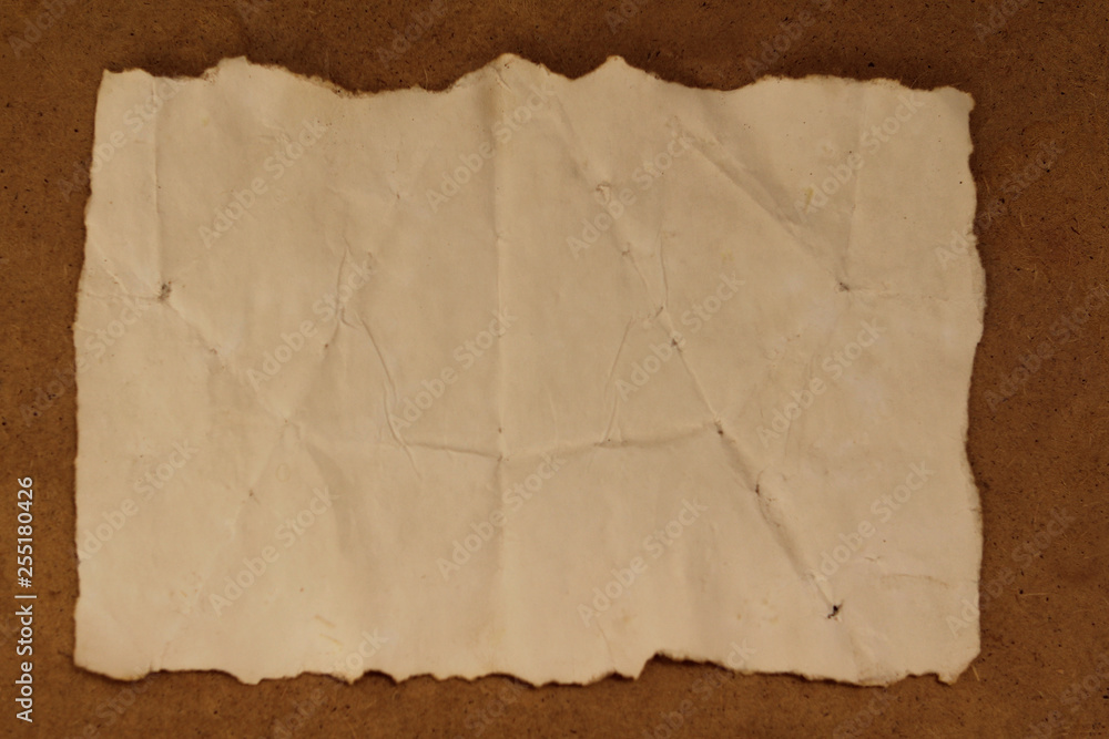Old brown crumpled paper, burned at the edges, background texture