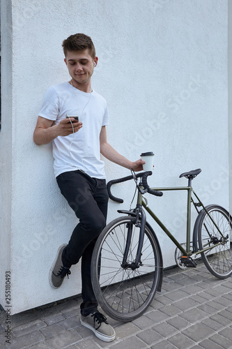 Handsome hipster man posing with bicycle in the city.