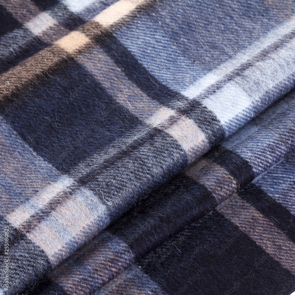 Close-up men's scarf in blue and white checkered fabric with folds for background Close-up men's scarf in blue and white checkered fabric with folds for background