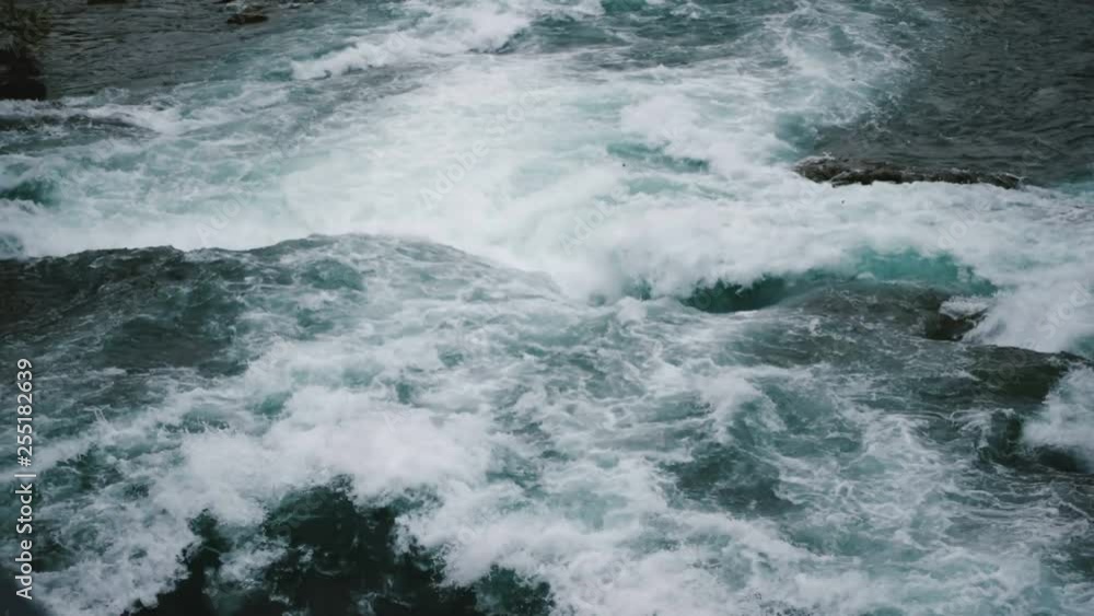 Epic close-up top view shot of powerful natural streams of water and foam rushing down at Niagara River slow motion. Epic close-up top view shot of powerful natural streams of water and foam rushing down at Niagara River slow motion.