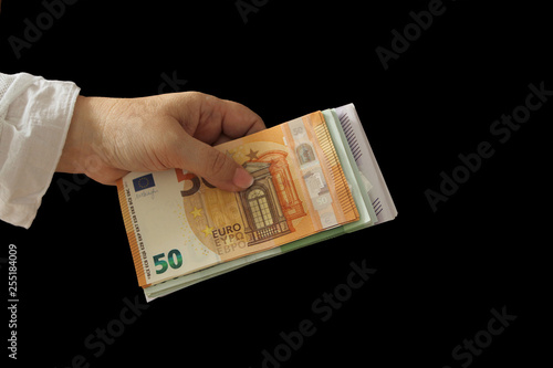 Female hands hold euro banknotes, close-up on a dark background