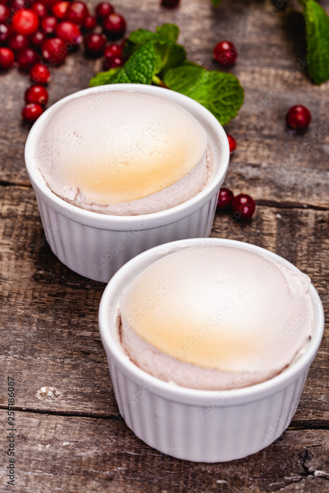 Souffle with cranberries in white ramekin on wooden rustic table. Close up Souffle with cranberries in white ramekin on wooden rustic table. Close up