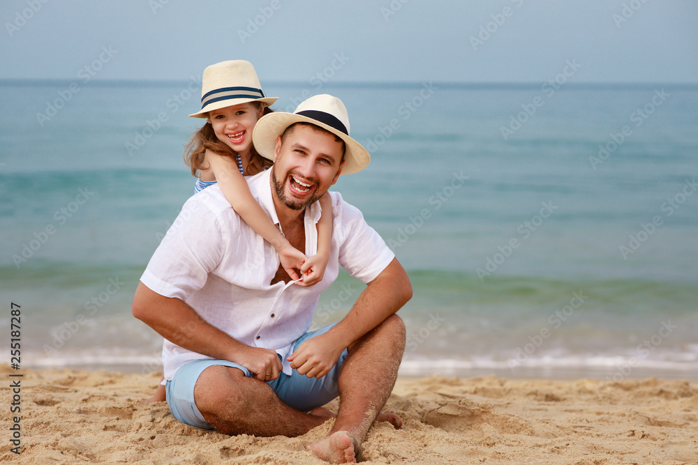 happy family at beach. father and child daughter hug at sea happy family at beach. father and child daughter hug at sea